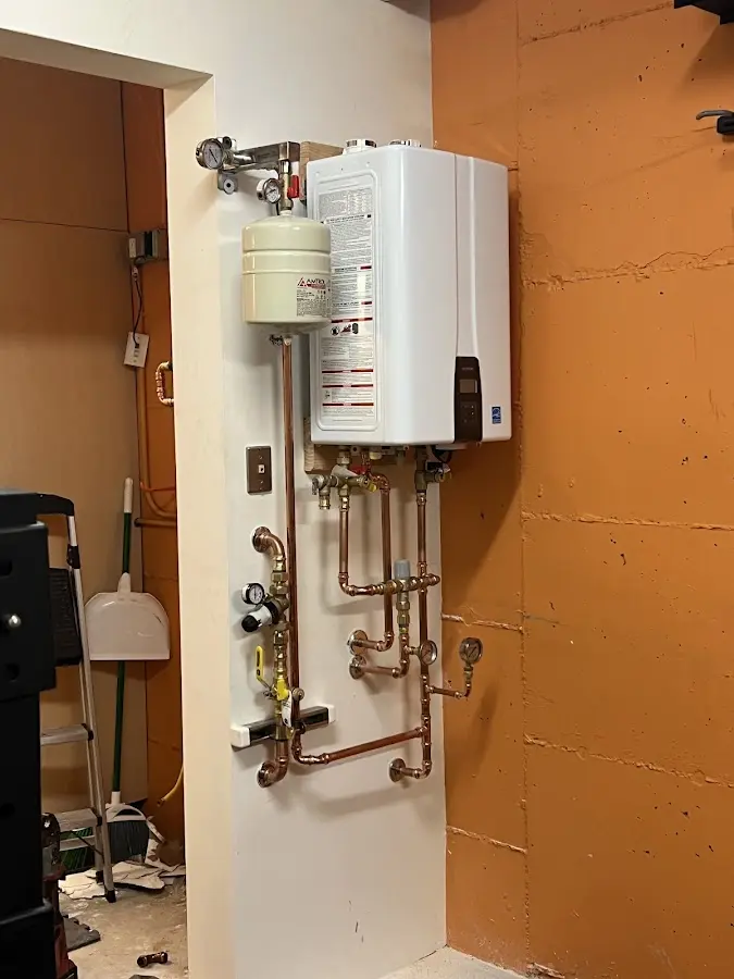 Plumbing technician inspecting water heater connections in Newburgh